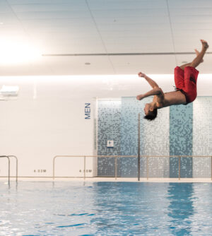 A person doing a flip off a diving board at the UBC Aquatic Centre