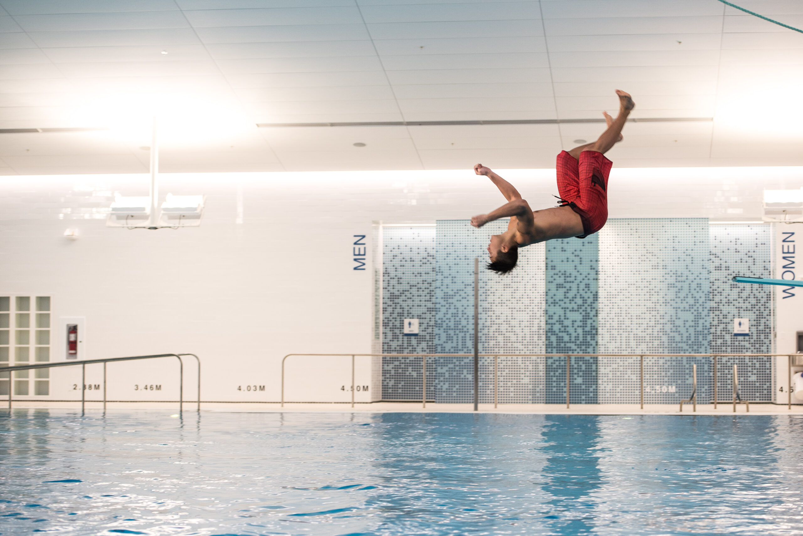 A person doing a flip off a diving board at the UBC Aquatic Centre